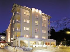 Hotel Laudinella in einem schlichten, modernen Gebäude mit Blick auf die verschneitenSchweizer Alpen