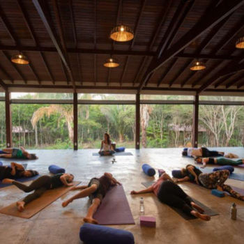Yogagruppe praktiziert Drehstellungen am Boden in den Yogaferien in Indien
