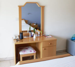 Die Zimmerausstattung des Hotels mit kleinem Spiegelschrank und Kühlschrank