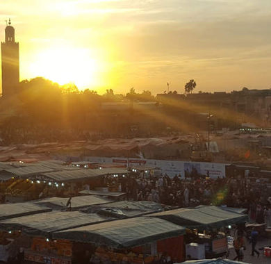 Der Markt von Marakesch mit dem Minarett im Hintergrund bei Sonnenuntergang