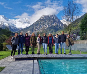 Yogagruppe portrait am Pool mit Bergen im Hintergrund