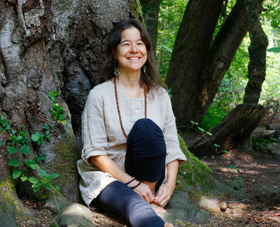Bettina Baumgartner sitzt unter einem Baum