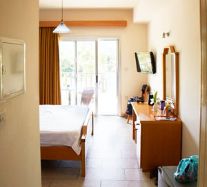 Ein Doppel Zimmerbeispiel des Aphroditehotels mit guter Klimaanlage, Kühlschrank und Fernseher mit Balkon